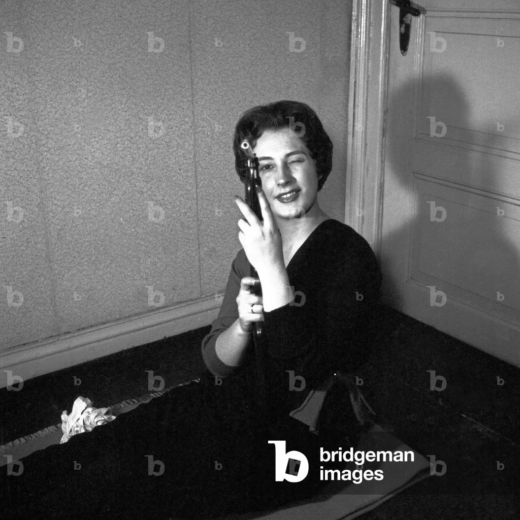 German schlager singer Renee Franke cleaning a rifle, Hamburg 1956