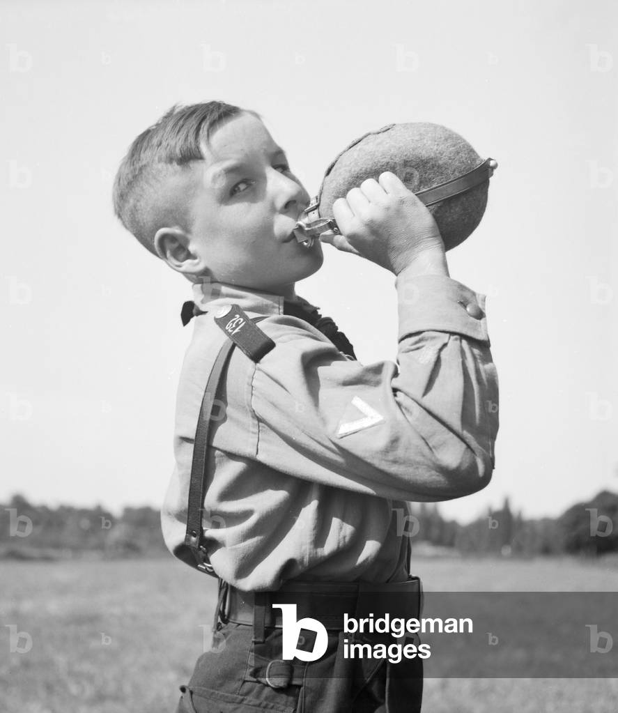 A Hitler youth drinking from his waterbottle, Germany 1930s (b/w photo)