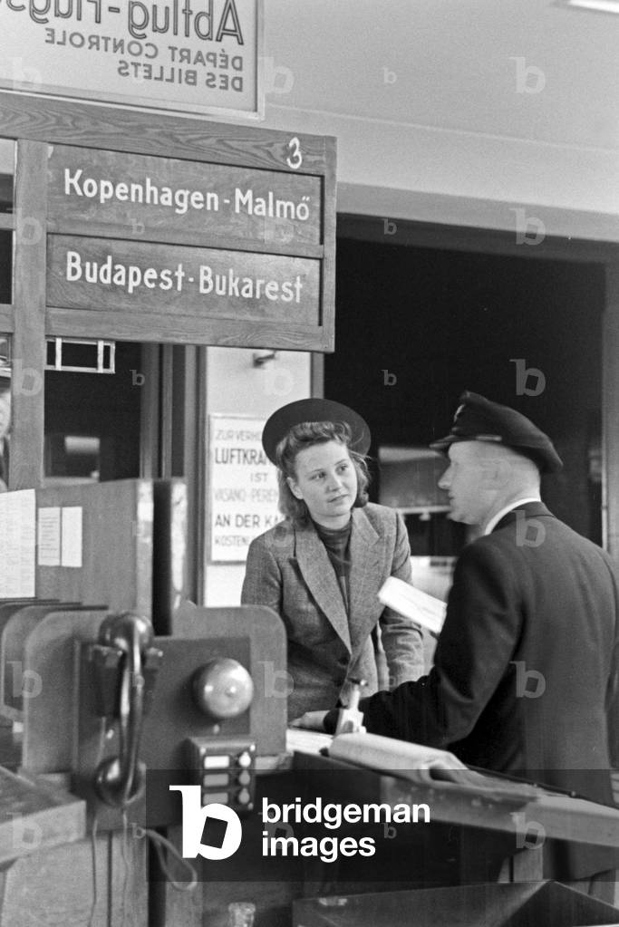 A female passenger with a customs officer at Berlin Tempelhof airport, Germany 1930s (b/w photo)