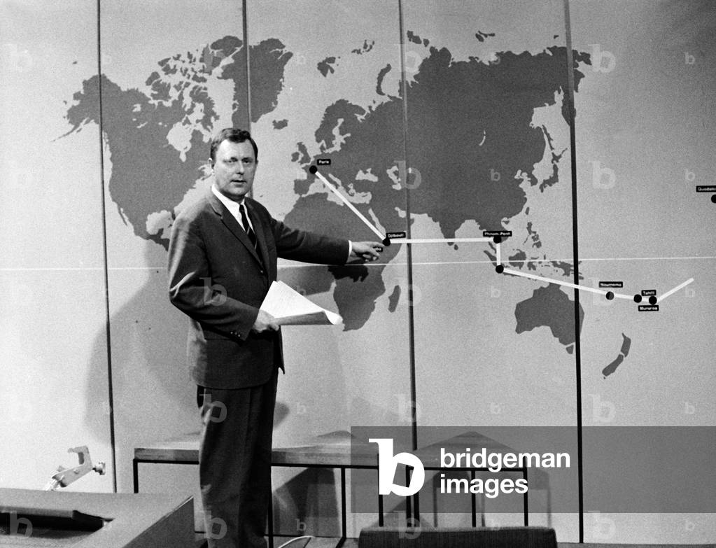 German reporter Gustav Trampe showing events on the world map in German news, ca 1967