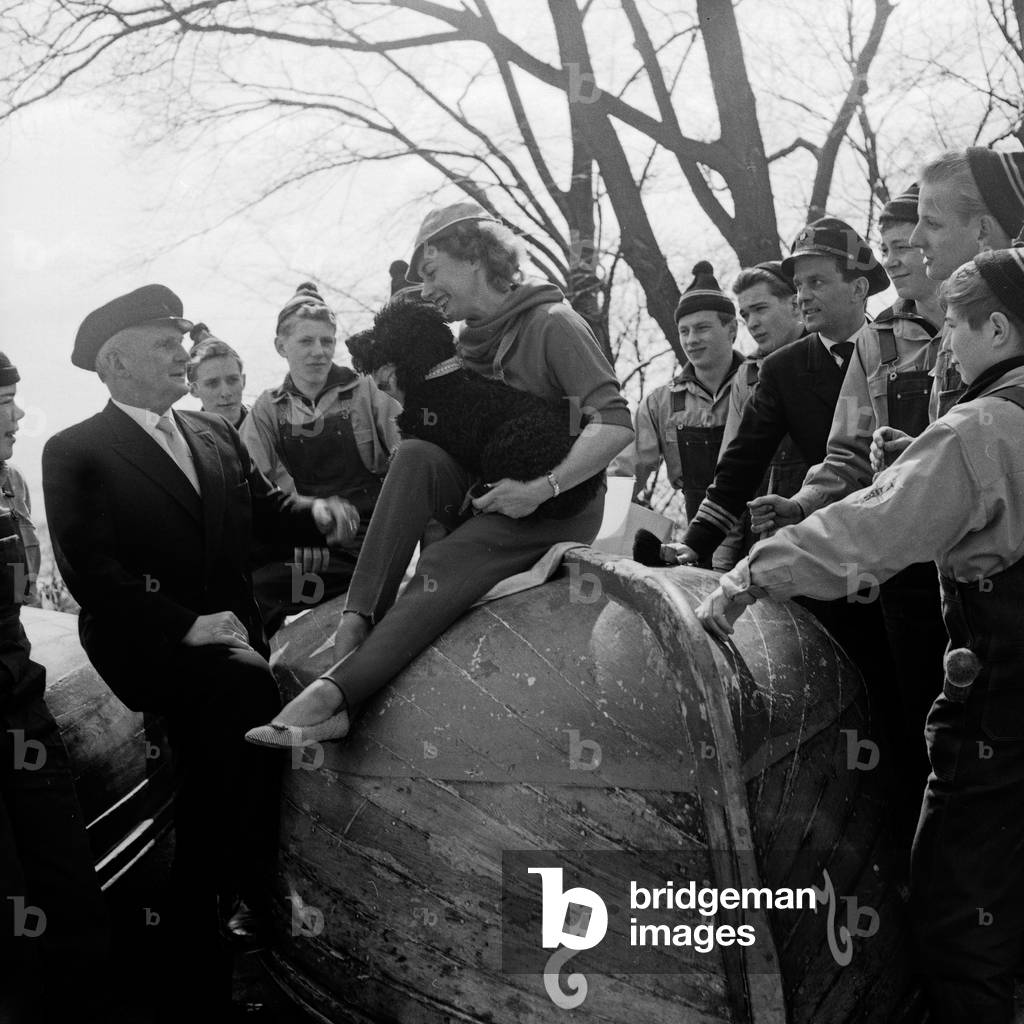 Actress Marina Ried with a poodle visiting a Speeldeel, a traditional folk group, Germany 1960s