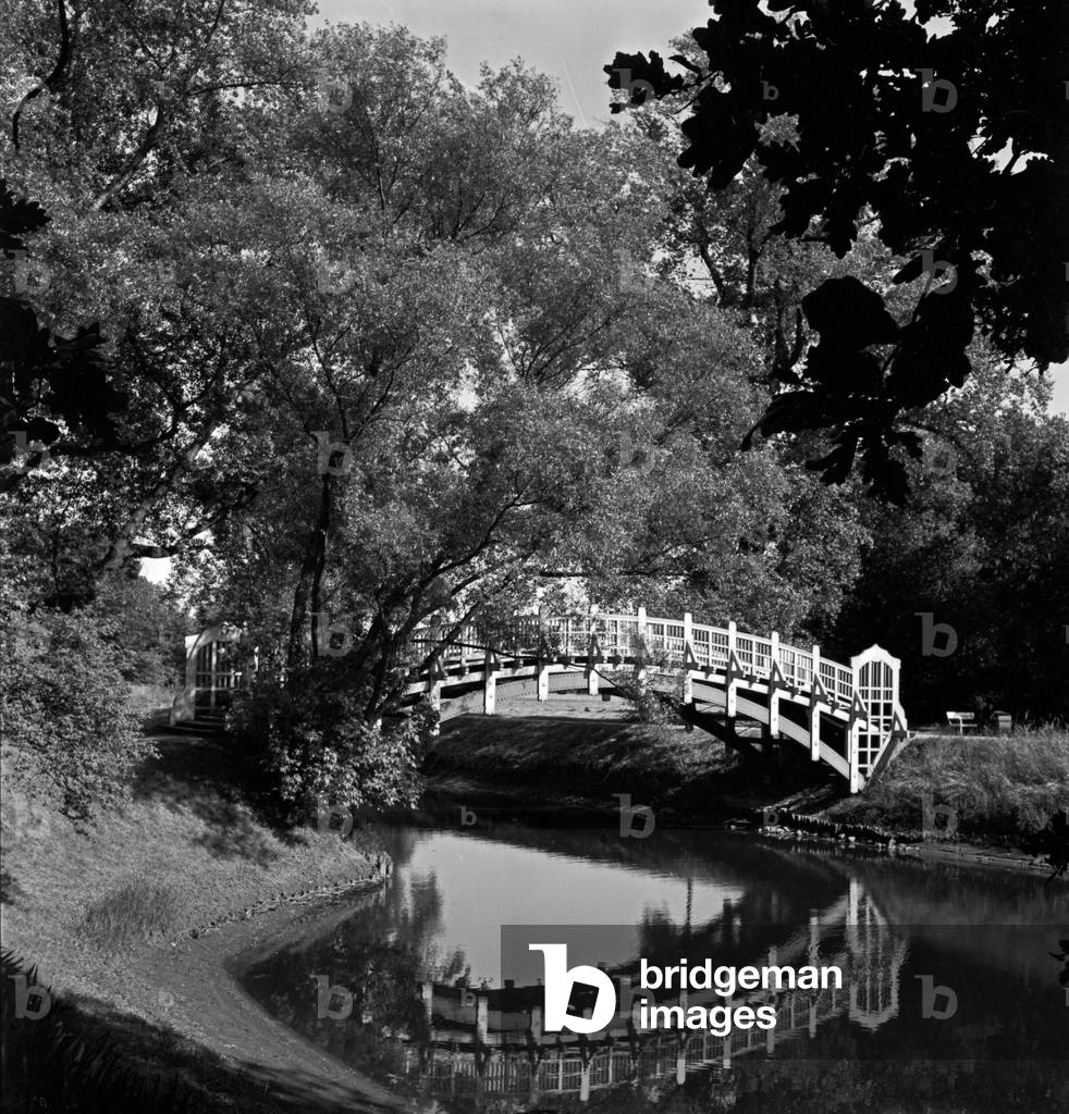 A little bridge leading over a pond near the exhibition tower and the Stadthalle hall of Magdeburg, Germany 1930s (b/w photo)