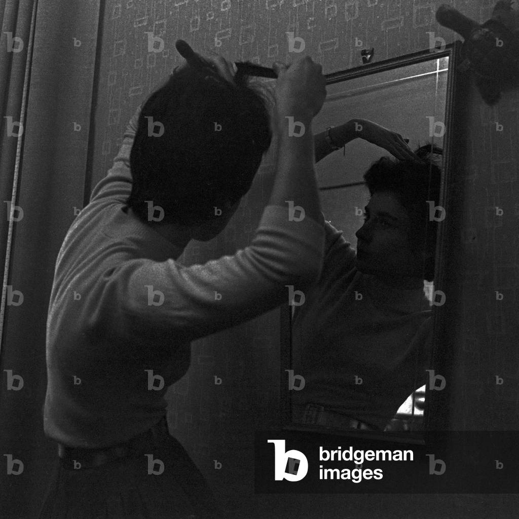 German schlager singer Melitta Berg combing her hair in front of a mirror, Germany 1950s
