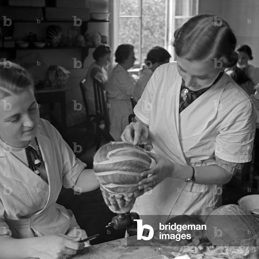 Two women doing the hairdressing on the doll heads at the Kaethe Kruse doll factory at Bad Koesen, Germany 1930s (b/w photo)