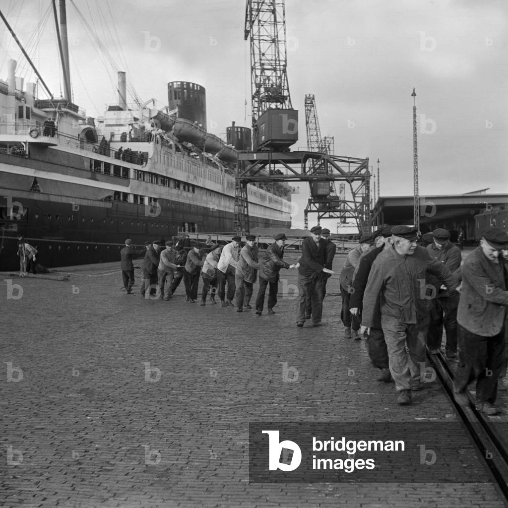 Harbor workers helping at the mooring of passenger ship 