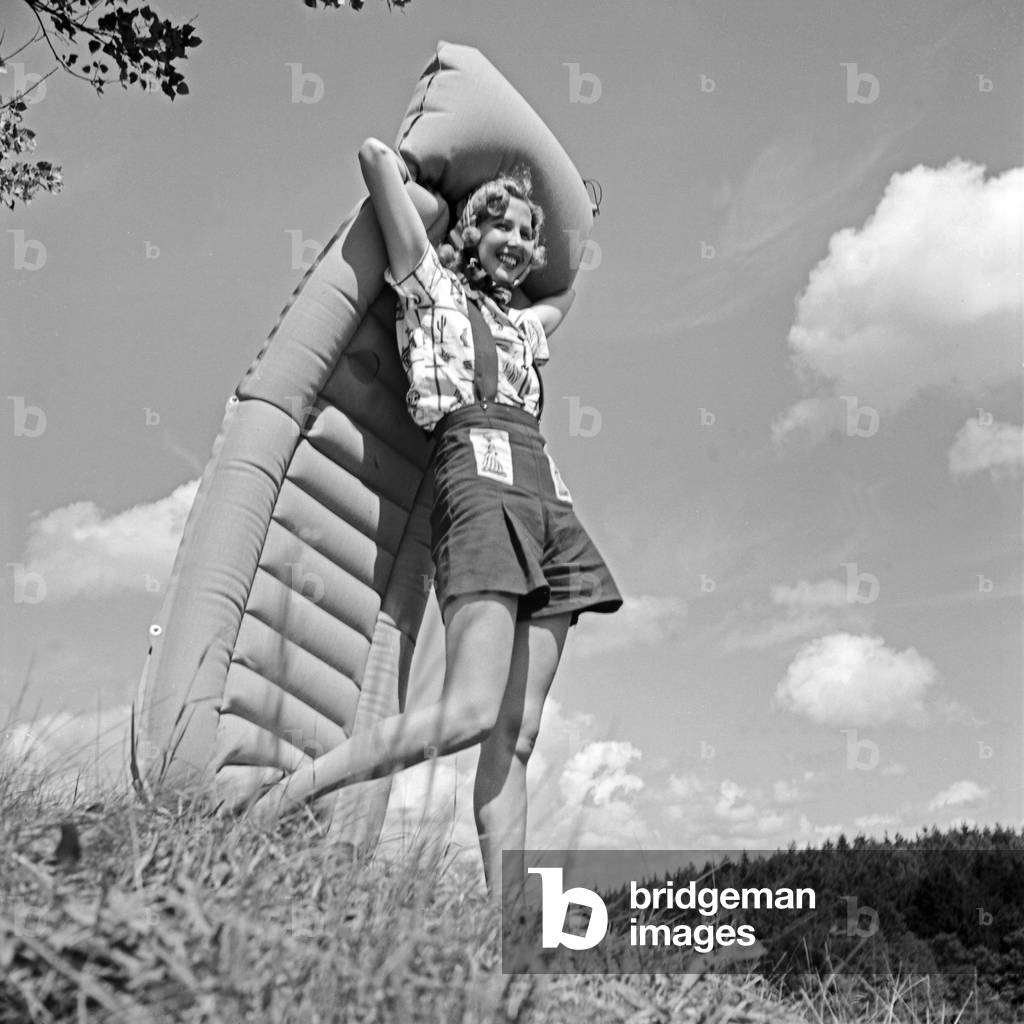 A young woman posing with an air mattress on a lawn, Germany 1930s (b/w photo)