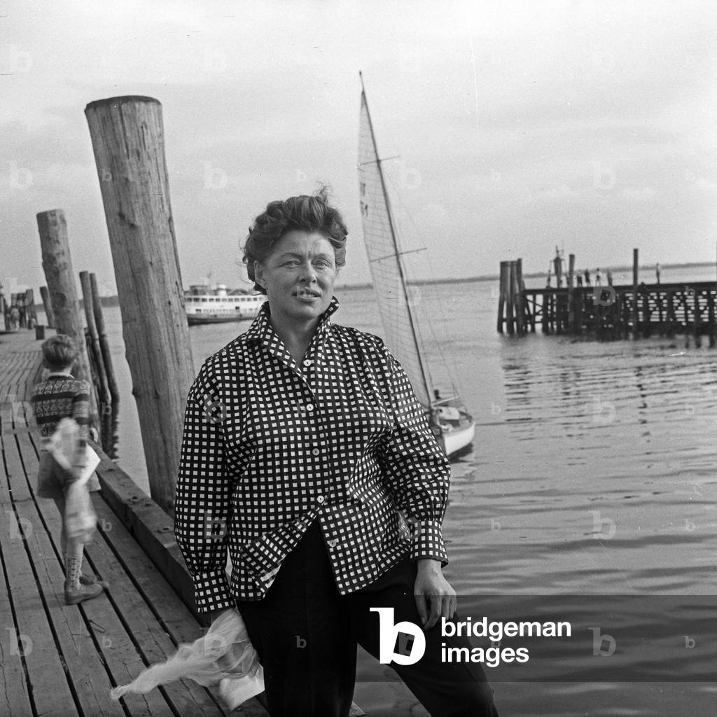 German actress Lotte Rausch wearing a plaid blouse on a boardwalk, Germany 1950s