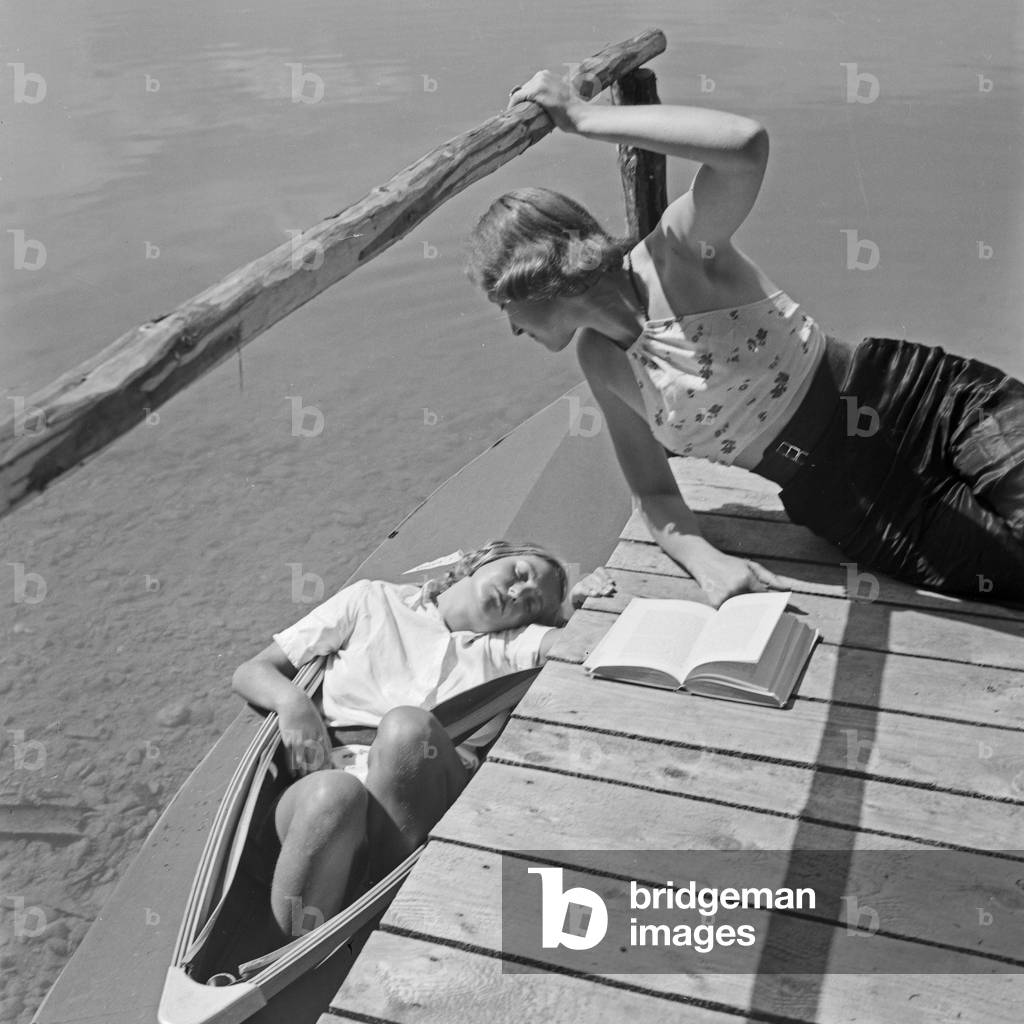 Two young women at a boardwalk on the shore of a lake in the Wachau area, Germany 1930s (b/w photo)