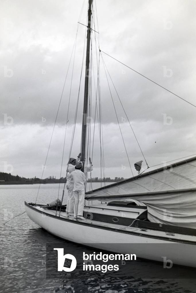 A group of sailors is preparing the canvas on the boat, Chiemsee, Germany 1930s (b/w photo)