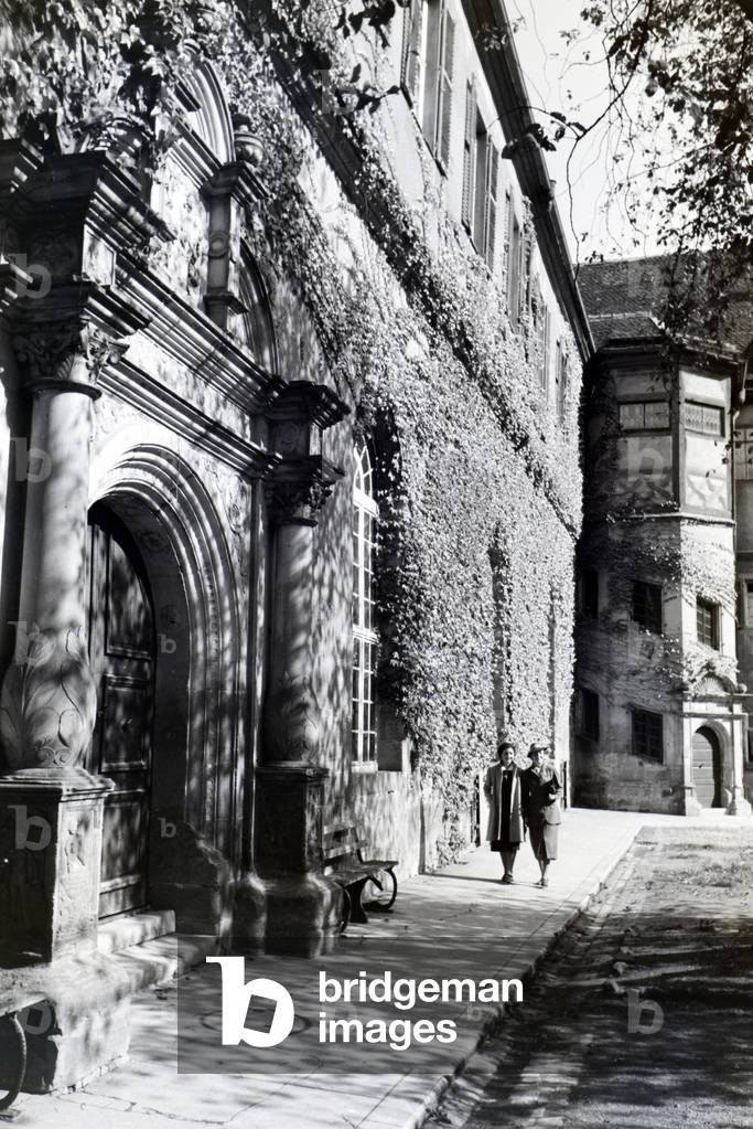 Two young ladies taking a walk in the patio of the Hohentübingen castle, Tübingen, Germany 1930s (b/w photo)