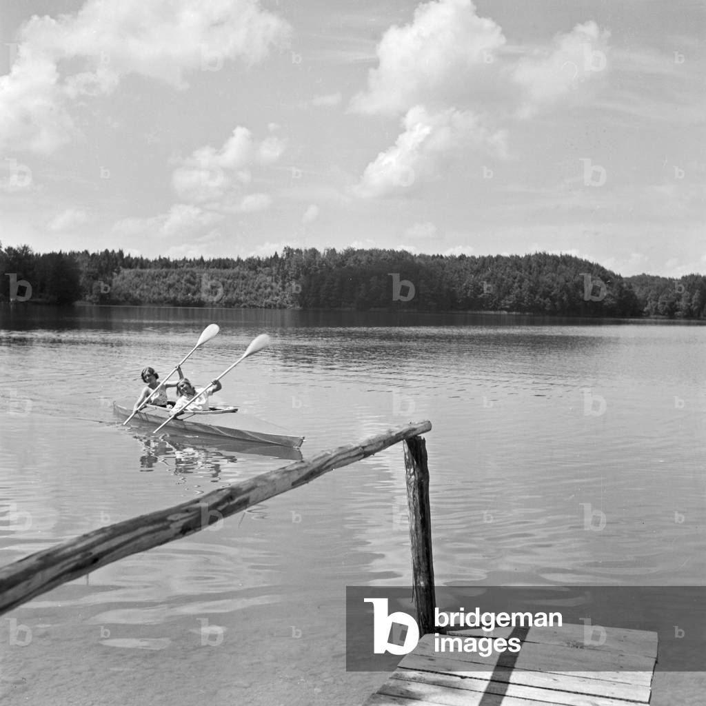 Two young women at a boardwalk on the shore of a lake in the Wachau area, Germany 1930s (b/w photo)