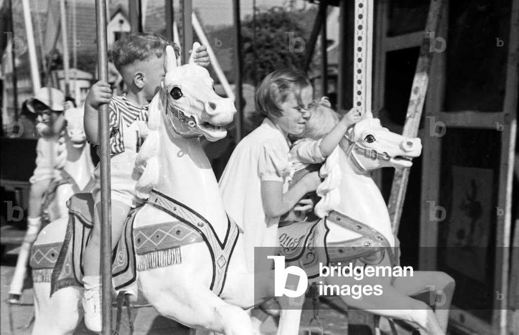 Children on a carousel at the annual radish fair at Schifferstadt, Germany 1930s (b/w photo)