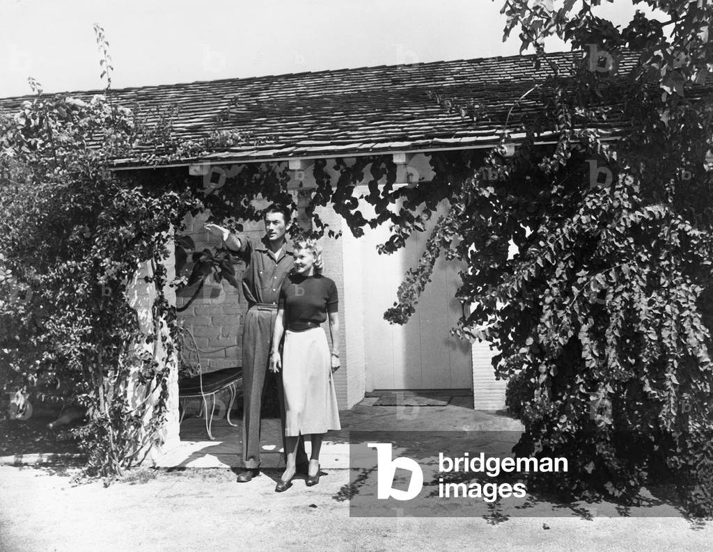 American actor Gregory Peck with his wife Greta in their garden, 1950s