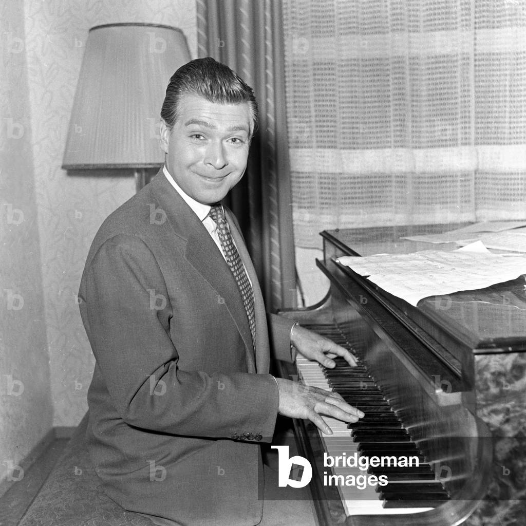German Schlager singer, composer and actor Bully Buhlan playing his grand piano in Hamburg 1954