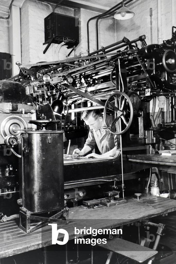 A worker adjusting the rotary printing press in the plants of the mechanical engineering company MAN (Maschinenfabrik Augsburg-Nürnberg), Germany 1930s (b/w photo)