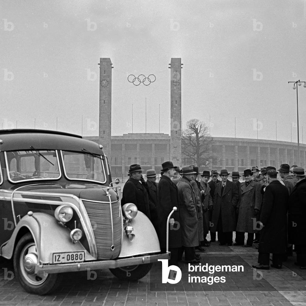 A traveller group ion front of their coach at the Olympic stadium in Berlin, Germany 1930s (b/w photo)