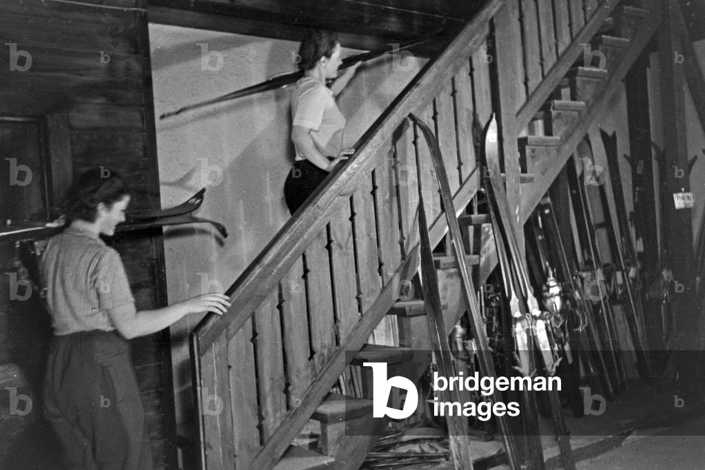 Two young beginners at the stairs of a training skiing hall, Germany 1930s (b/w photo)