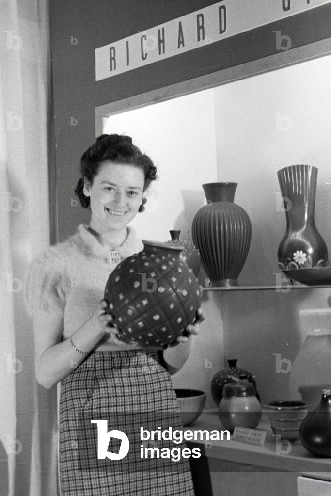 A visitor of the Leipziger Frühjahrsmesse in front of a stand of the porcelain factory Richard Ginori, Germany 1941 (b/w photo)