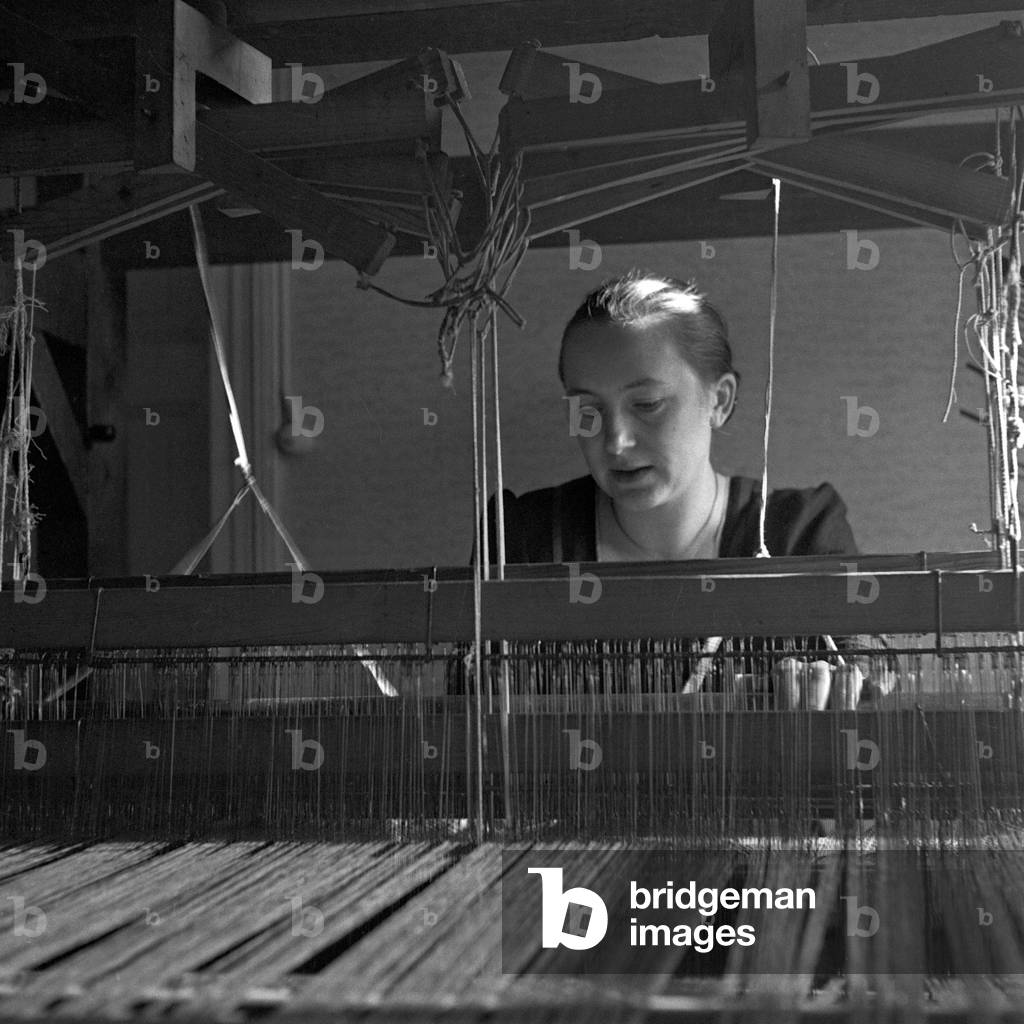 A woman at a weaving loom at the school for weaving at Sommerfeld, Germany 1930s (b/w photo)