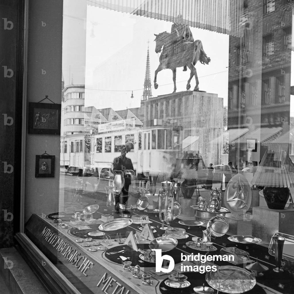 reflected in the showcase of a household goods store on Burgplatz in Essen, Germany 1930s (b/w photo)