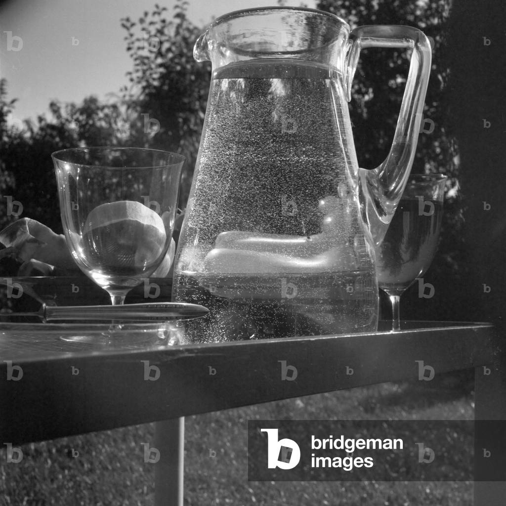 Bowl of fruits with a decanter full of water, Germany 1930s (b/w photo)
