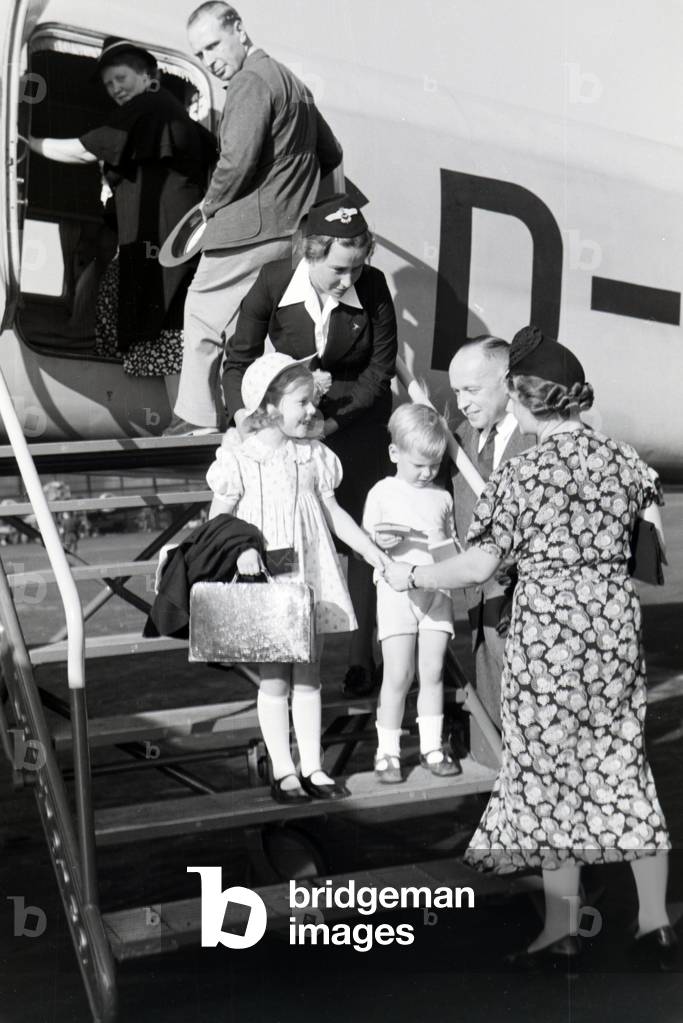 Stewardess helping children arriving, departing, entering, leaving a plane, Germany 1930s (b/w photo)