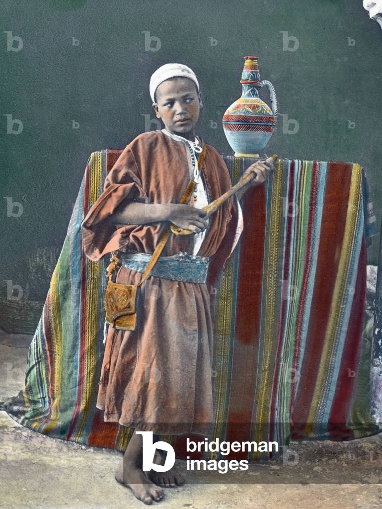Morocco, a boy playing Gumbri, image date: circa 1910. Carl Simon Archive