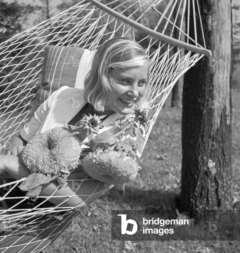 A young woman in the garden in summertime, Germany 1930s (b/w photo)