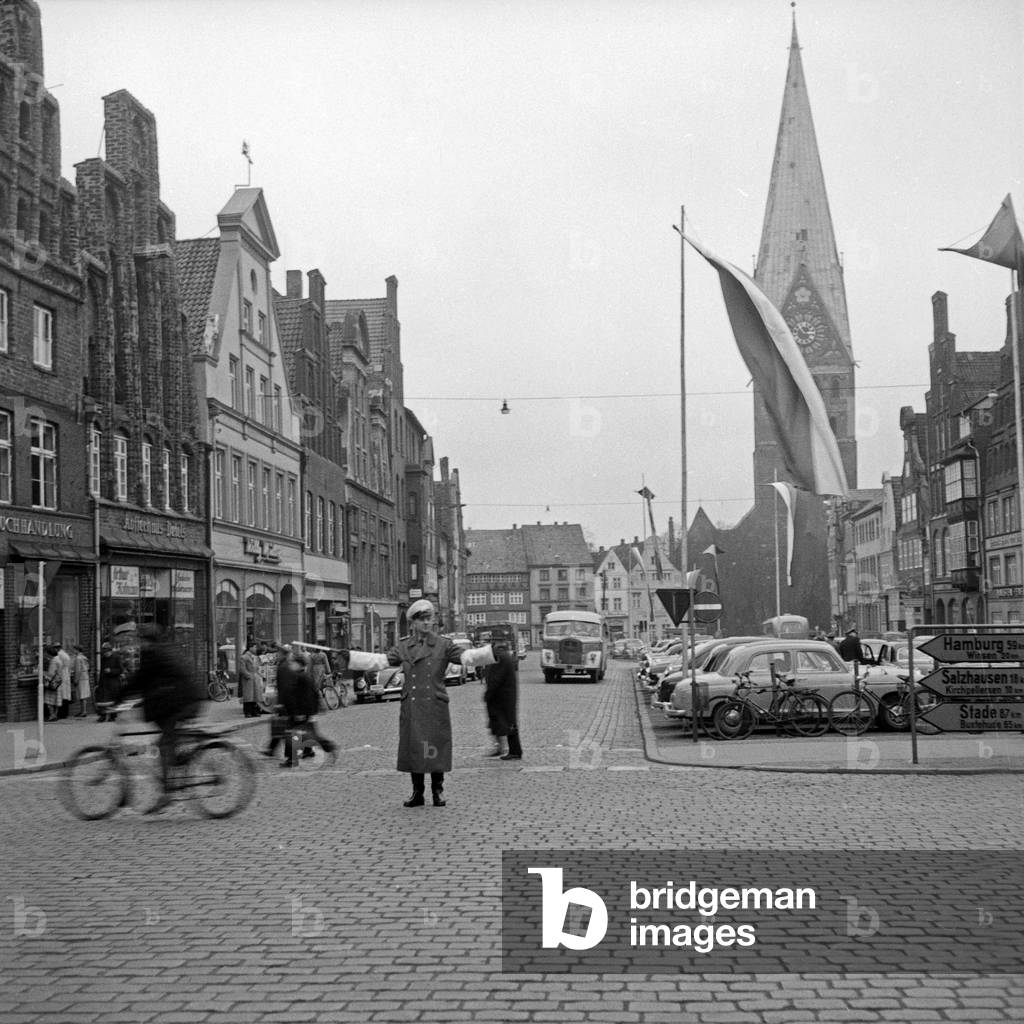 A policeman serving the traffic in a street of Luenburg, Germany