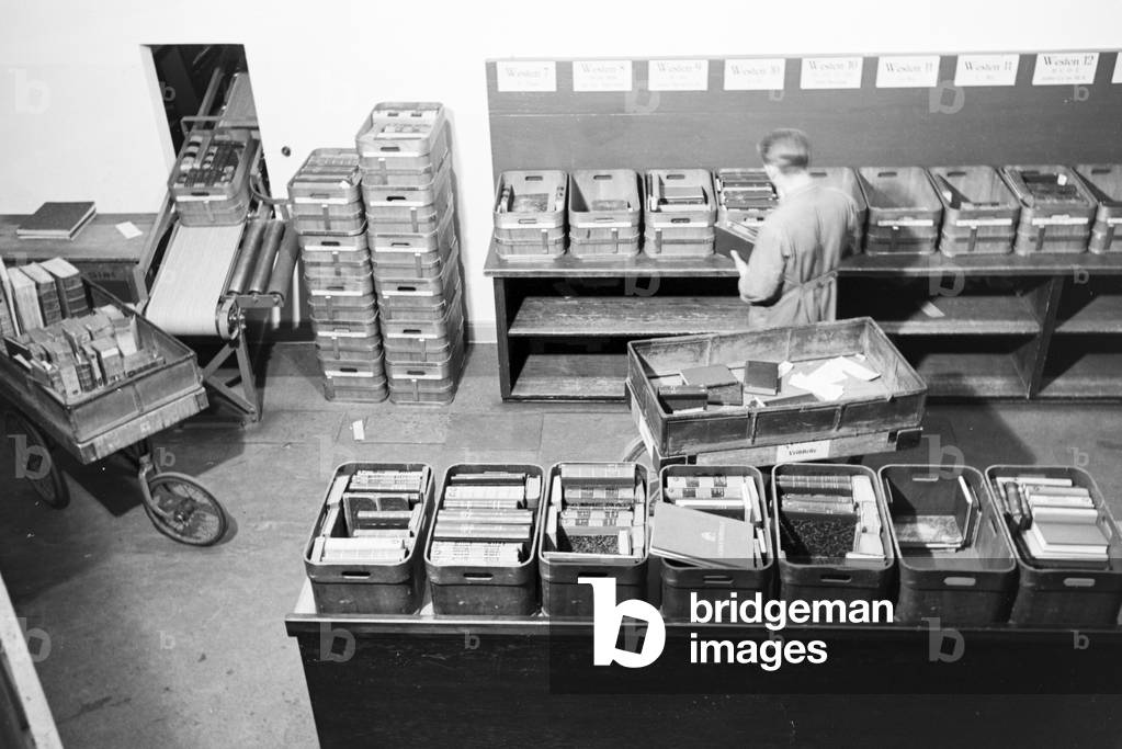 A librarian of the Berlin State Library (former Prussian State Library) sorting books in alphabetical order in the library magazine, Germany 1930s (b/w photo)