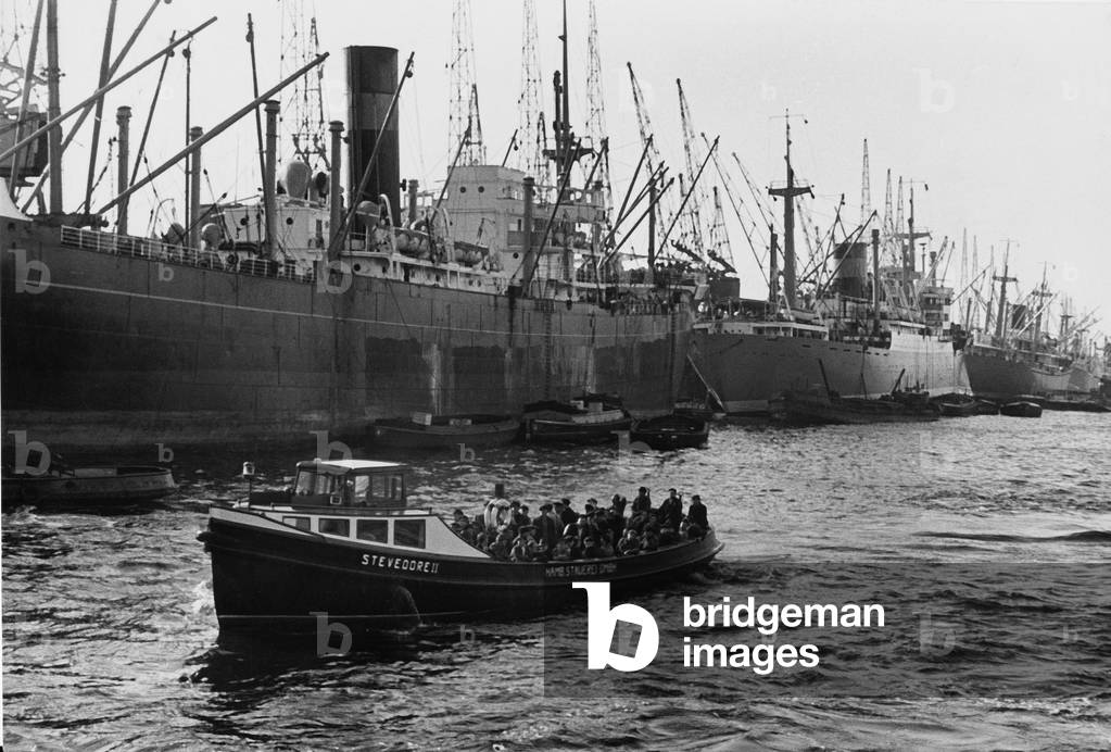 A little barge on its way alongside the bisg ships in the port of Hamburg, 1950s