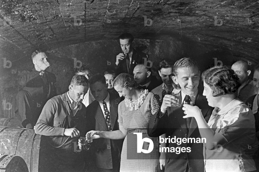Guests checking the new vintage at the wine cellar, Germany 1930s (b/w photo)