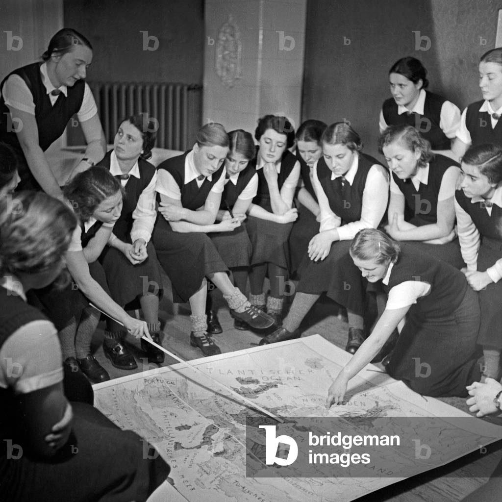 Women discussing a map of Europe in their ideological lesson at the female workforce group of Molkenberg, Germany 1930s (b/w photo)