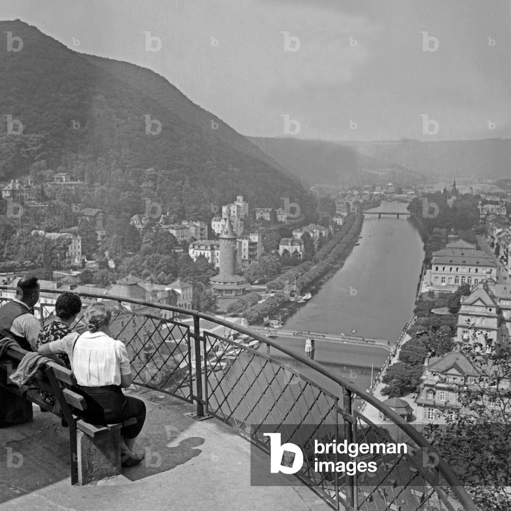 People sitting above the shore of river Lahn and enjoying the view at Bad Ems, Germany 1930s (b/w photo)