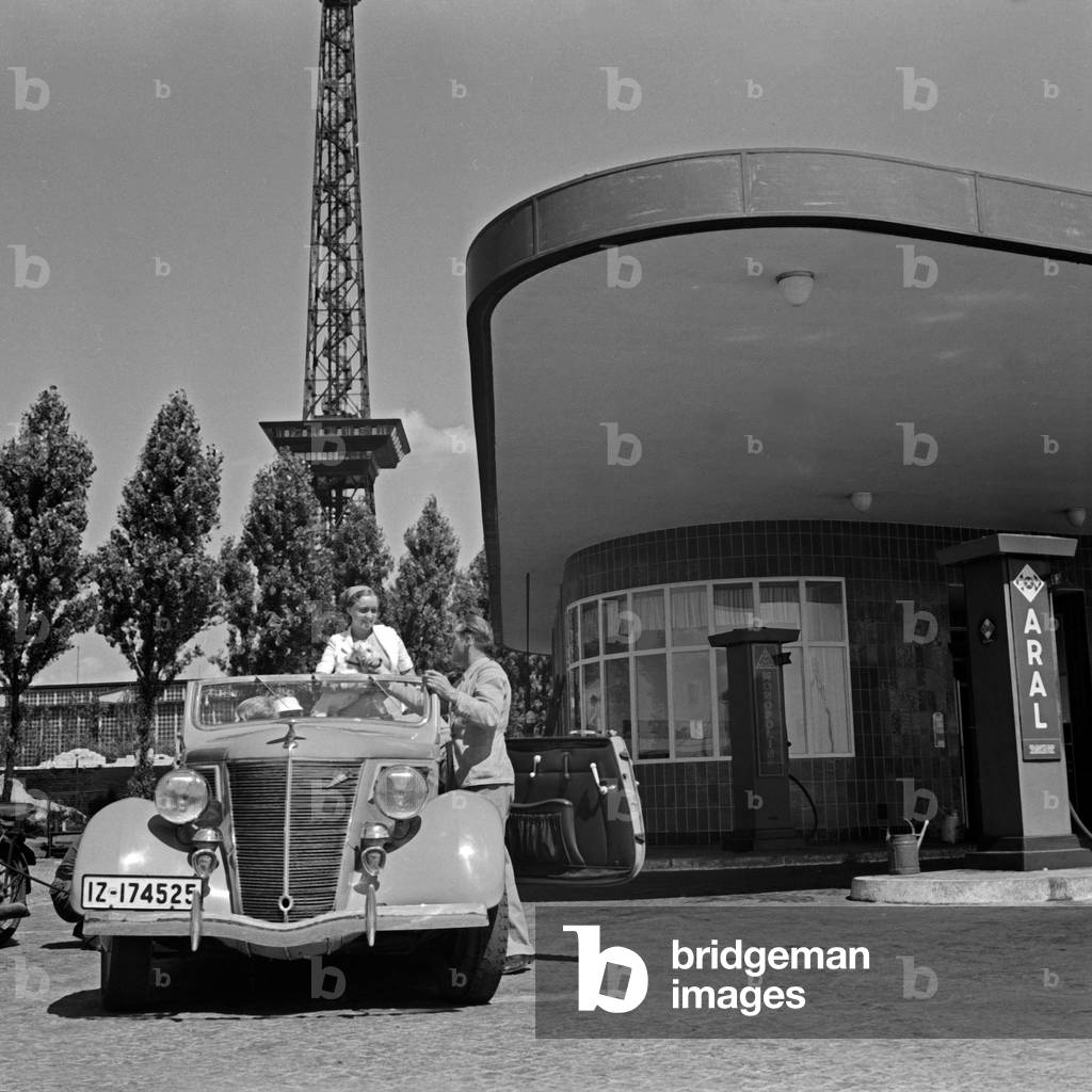 A family stops at an Aral petrol station near the Berlin radio tower, Germany 1930s (b/w photo)