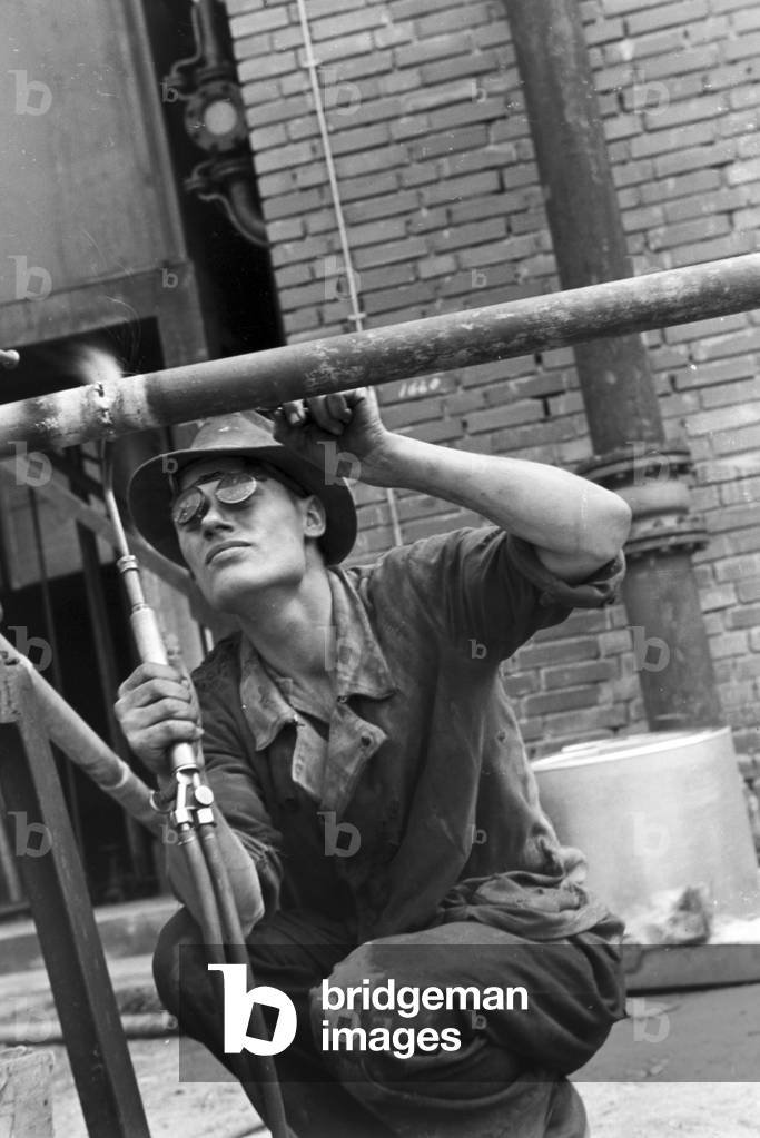 A welder bonding different components, Witten, Germany 1930s (b/w photo)