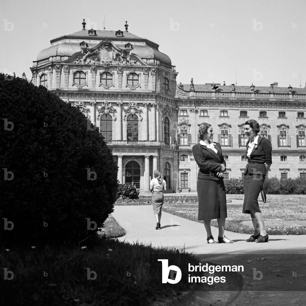 Two women chatting in front of Wuerzburg Residence, Germany 1930s (b/w photo)