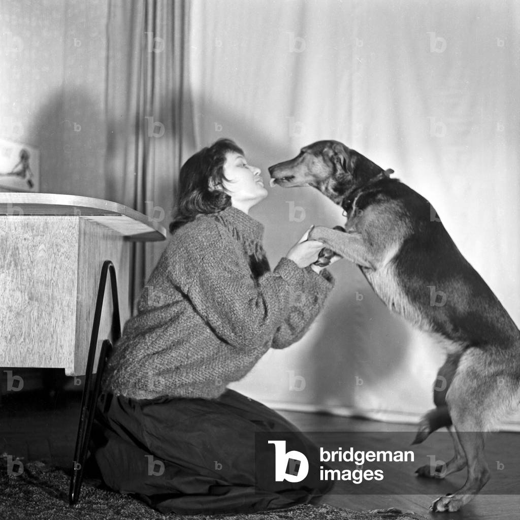 A young woman playing with her dog, Germany 1950s