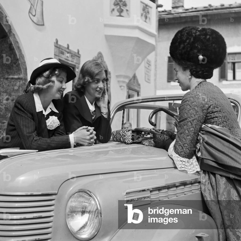 Two women getting a drink by a woman in Black Forest array, Germany 1930s (b/w photo)