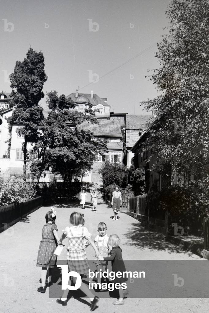 A group of children singing songs to a children´s dance in Bad Blankenburg, Germany 1930s (b/w photo)