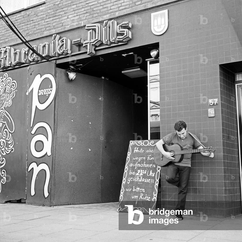 A musician doing rehearsals at the entrance of famous folk club 