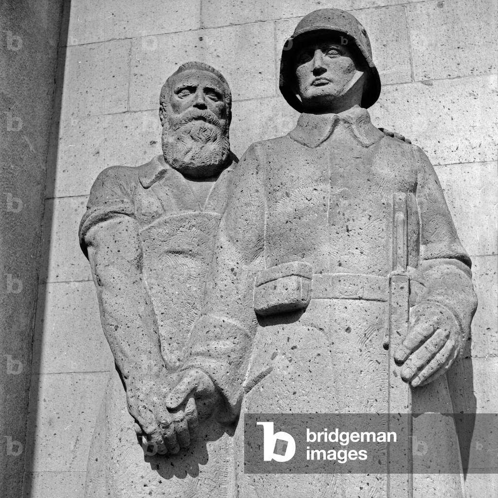 Sculpture group craftsman and soldier at the memorial for the fallen soldiers of WWI at Bad Nauheim, Germany 1930s (b/w photo)