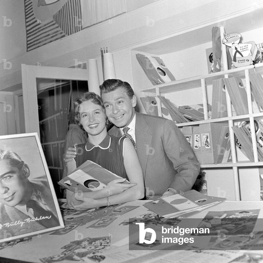 German Schlager singer, composer and actor Bully Buhlan and a shop assistant in a record store in Hamburg 1954