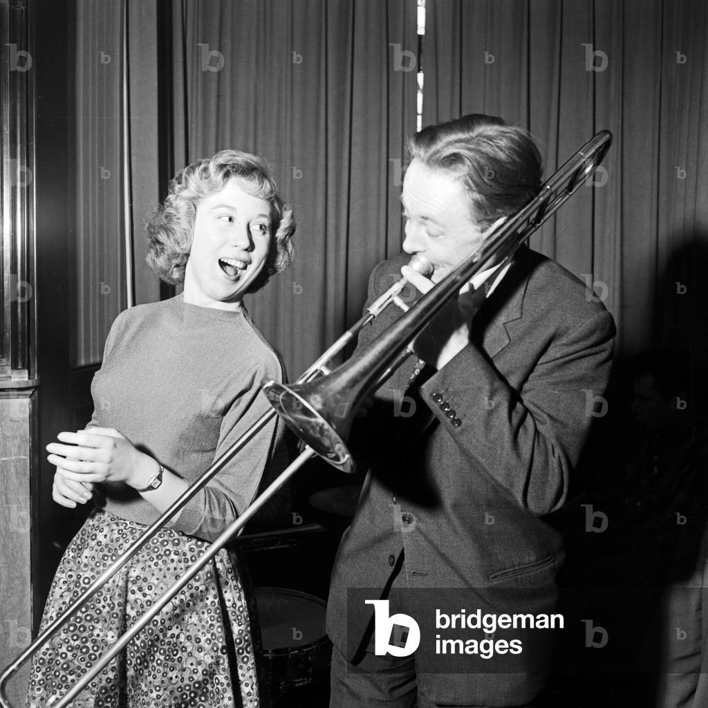 Jazz trombonist Chris Barber and blues inger Ottilie Patterson exercsing at his hotel room, Germany 1950s