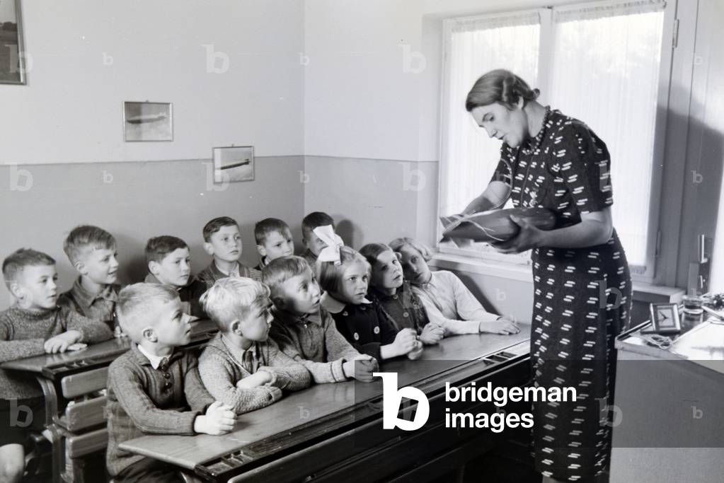 In the school of the zeppelin village near Frankfurt am Main, already the youngest pupils were instructed in the structure of a zeppelin by their teachers, here with the help of an aircraft model, Germany 1930s (b/w photo)