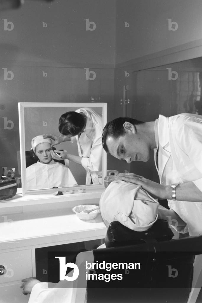 A male staff member preparing the make up at Haus der Schoenheit beauty salon, Germany 1930s (b/w photo)