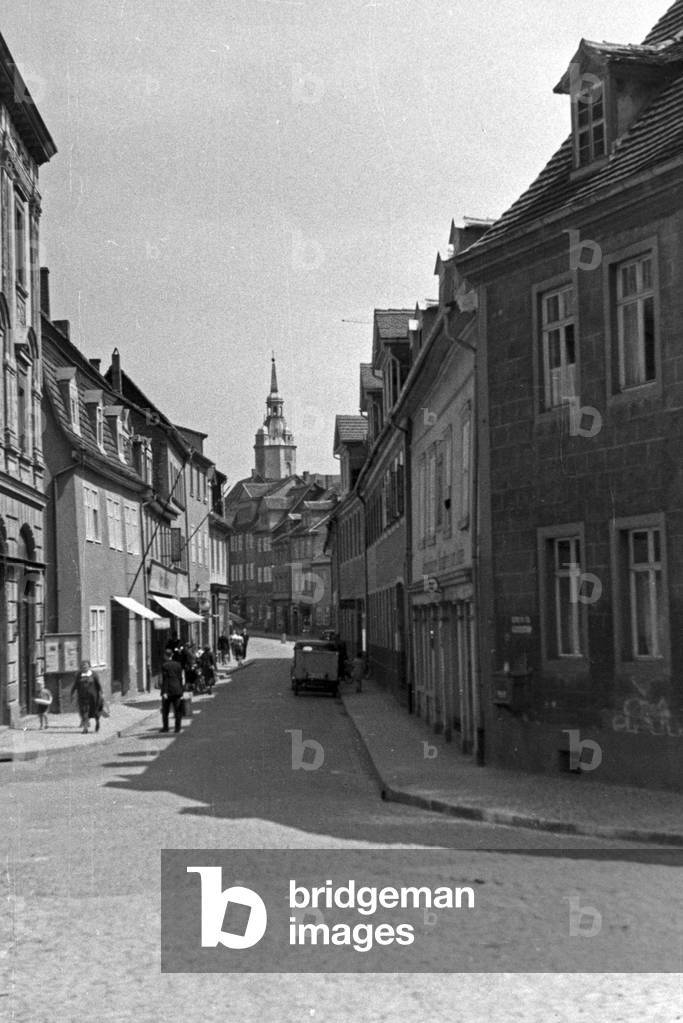 View through an old city street to a belfry, Germany 1930s (b/w photo)