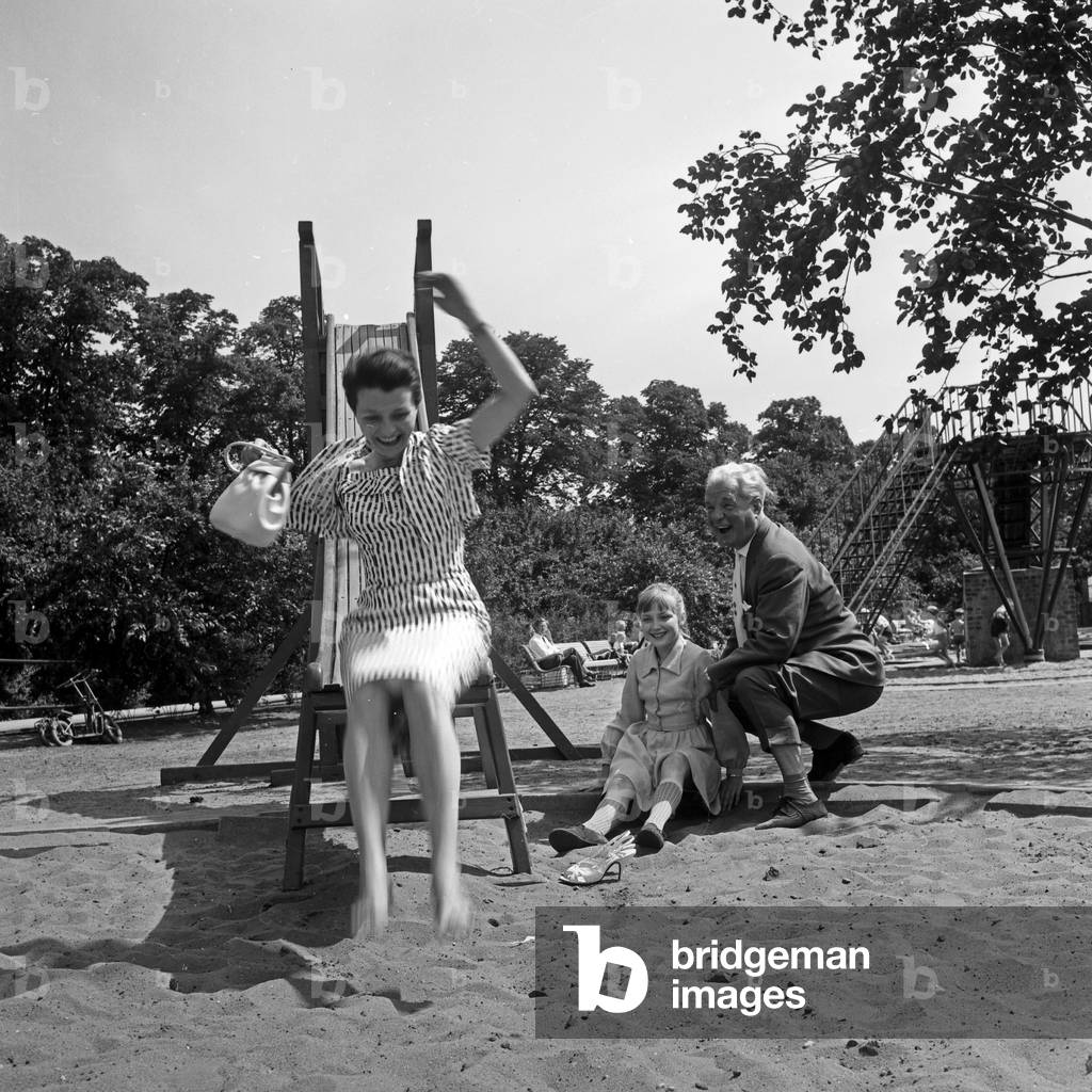 German television announcer Irene Koss on the chute of the playground at Planten un Blomen public gardens in Hamburg, Germany 1950s