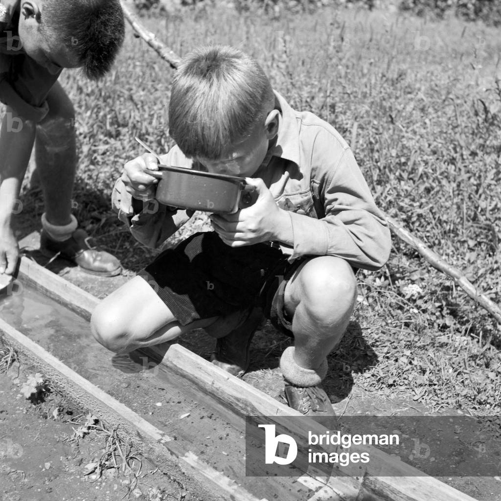Hitler youths drinking from a well at Spitz, Lower Austria, Austria 1930s (b/w photo)