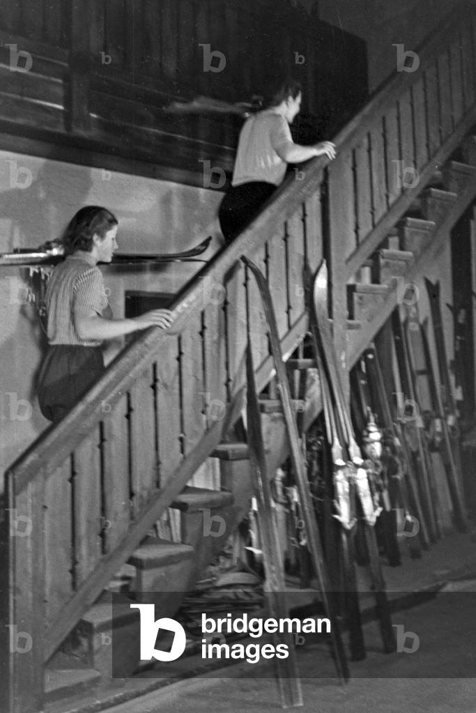 Two young beginners at the stairs of a training skiing hall, Germany 1930s (b/w photo)